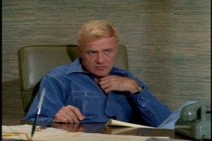 We cut to the office where Bill is wearing his Denim Shirt of Manual Labor and Occasional Ass-Kicking.