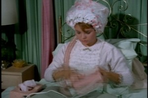 To pass the time, she washes and sets her hair, only to find that her hair dryer is on the fritz. 