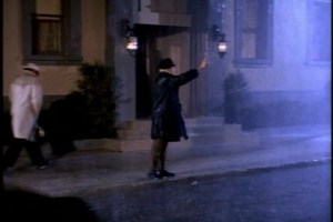 Soon, it's raining again in the city, and Bill is searching in vain for a cab. (He should really think about buying an umbrella.)