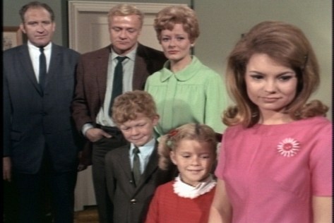 The adults look on sadly, but the children seem oblivious.