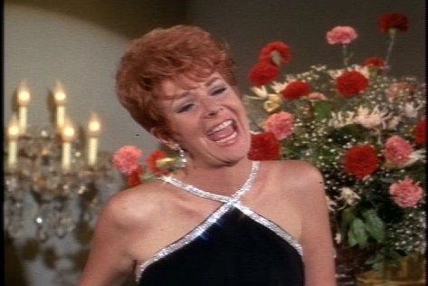 Or at least lip-syncing awkwardly to what may or may not be her own voice.