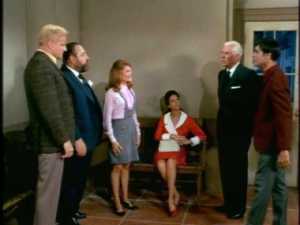 Back in Sitges, everyone is still sitting around the police station when Ricardo enters with a distinguished-looking gentleman.