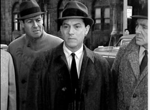 The jeering crowds that gather around Adam even toss out the ultimate Cold War-era insult, comparing him to Communist security forces.